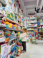 Budva, Montenegro - 01 november 2023. Little girl holding a set of toys in the store photo