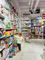 buda, montenegro - 01 noviembre 2023. pequeño niña elige un juguete conjunto en un Tienda estante foto