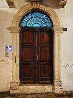 Budva, Montenegro - 25 december 2022. Arched wooden door in an old mansion photo