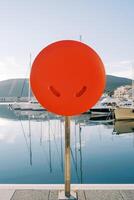 Life buoy in a box stands on a pier with moored yachts photo