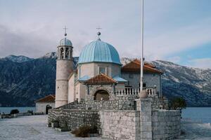 Iglesia de nuestra dama en el rocas en un pequeño artificial isla en el bahía de kotor. montenegro foto