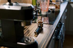 Cone with poured ground coffee lies on the table near the coffee machine photo