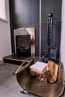 Metal rack with firewood near the fireplace with accessories photo