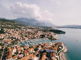 View over the red roofs of houses to rows of moored yachts. Porto, Montenegro. Drone photo