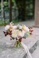 Wedding bouquet stands on a stone slab in the garden photo