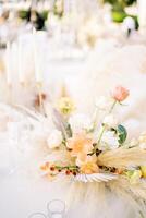 Bouquet of flowers stands on a festive table near empty glasses photo