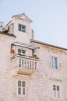 Ancient stone building with an attic and a carved small balcony photo
