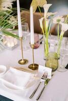 Name card stands next to a plate and a bouquet of flowers on the festive table photo