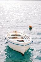 White fishing boat moored in the sea photo