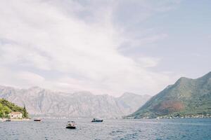 Motorboats sail along the Bay of Kotor against the backdrop of green mountains. Montenegro photo