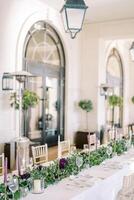 Set festive table with flowers and candles near gas heaters photo