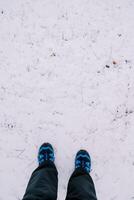 pies en azul trekking botas estar en el nieve. parte superior ver foto