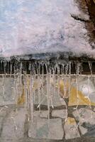 Icicles hang from the snow-covered roof of a house photo