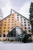 moderno hotel bianca con panal ventanas y un triangular techo en un Nevado bosque. colasina, montenegro foto