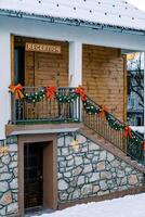 Wrought iron handrails above the stone steps of the hotel are decorated with garlands and red bows. Caption. Reception photo