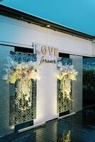 Light stand with bouquets of flowers on the terrace. Caption. Love forever photo