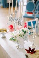 Bouquet of flowers stands on the table next to flat bread on a plate and candles in front of the mirror. Persian ceremony photo