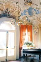 Colorful chandelier hangs from the painted ceiling of an ancient villa. Lake Como, Italy photo