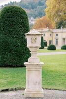 Marble flowerpot with lid in the green garden of an ancient villa photo