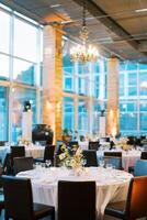 Set round festive tables in a restaurant with large windows and columns photo