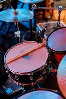 Pair of drumsticks lies on a drum kit on stage photo