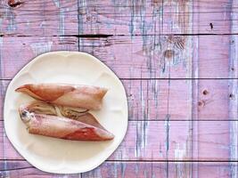 Squid On Wooden Background photo