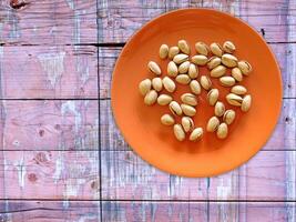 Pistachios On The Wooden Background photo