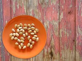Pistachios On The Wooden Background photo
