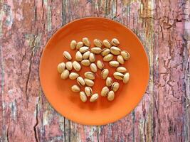 Pistachios On The Wooden Background photo