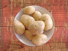 Potatoes On The Wooden Background photo