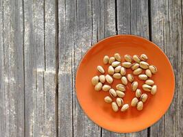 Pistachios On The Wooden Background photo