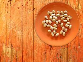 Pistachios On The Wooden Background photo