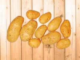 Potatoes On The Wooden Background photo