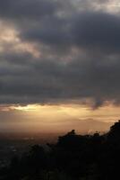 dramático amanecer con oscuro nubes en el cielo terminado el montañas, gorontalo, Indonesia foto