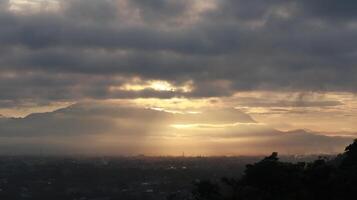 dramático amanecer con oscuro nubes en el cielo terminado el montañas, gorontalo, Indonesia foto