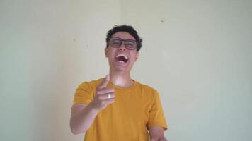 Young Indonesian curly man wear yellow t-shirt lot of lough moment.  The footage is suitable to use for man expression and people advertising content media. video