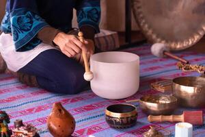 Close-up of a woman's hands playing a quartz singing bowl. photo