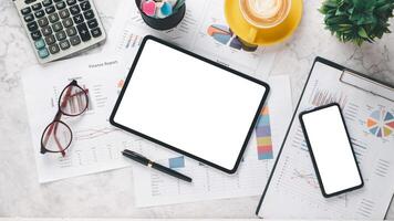 Professional financial workspace with reports, graphs, calculator, and digital devices on a marble surface. photo