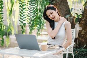 Woman takes a relaxing break from work, enjoying the tranquil environment of an outdoor garden cafe. photo