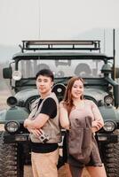 Young man and woman stand confidently in front of an off road car, exuding adventure and camaraderie. photo