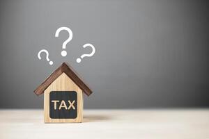 Estate tax planning. Model house with question mark with copy space photo