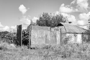 hermosa y antigua casa de campo abandonada en el campo sobre fondo natural foto