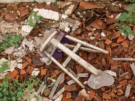 broken wooden chairs lying in the ruins of an old building photo