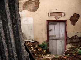 a wooden door in a house that has been abandoned by its occupants photo