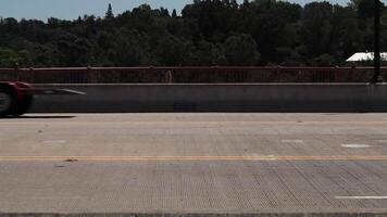 folsom, ca, 2010 - handhållen skott av bil trafik på bro med grön träd och blå himmel i bakgrund video