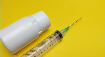 injectable pill medication on a yellow background photo