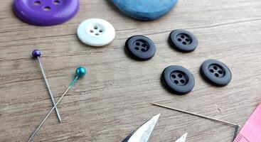 Sewing accessories on a wooden background Sewing accessories thread scissors pins tape measure. photo