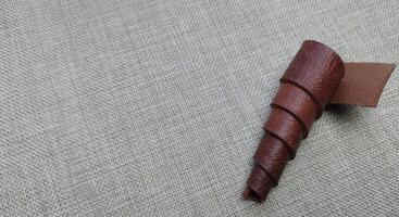 un pedazo de marrón cuero en un lino Manteles con Copiar espacio foto
