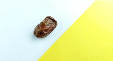 Dried date fruit on yellow and white background. Copy space. photo