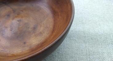 Empty wooden bowl on a linen tablecloth, top view, copy space photo